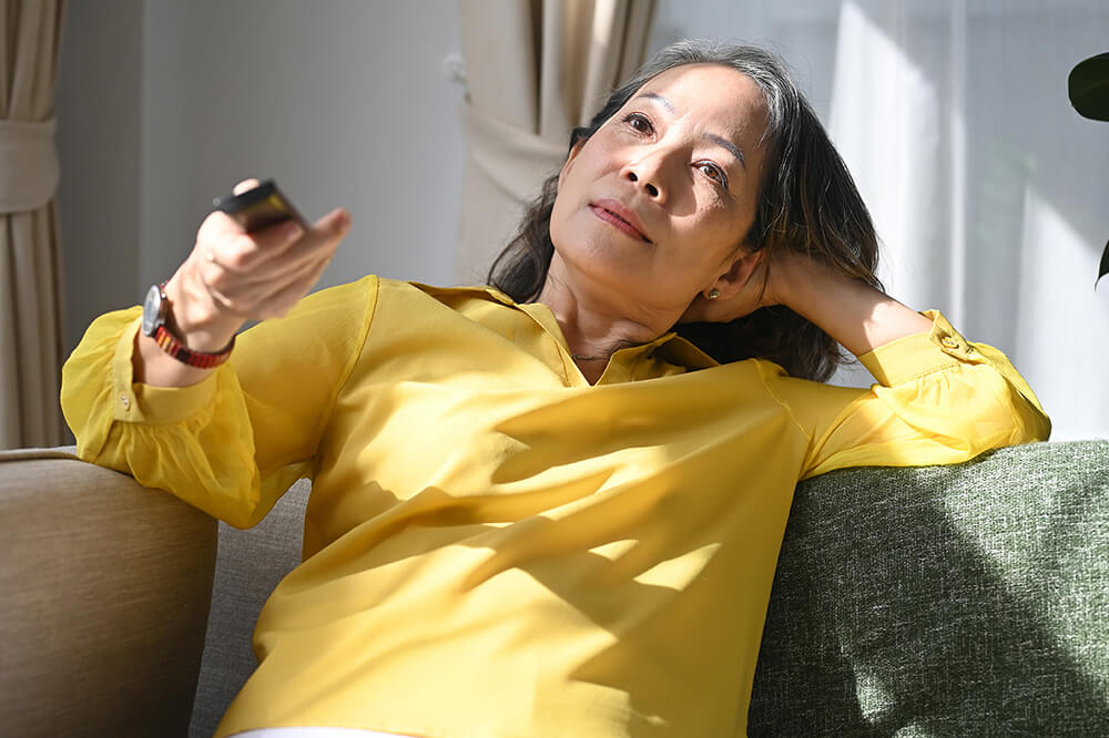 Deaf woman on couch with remote control