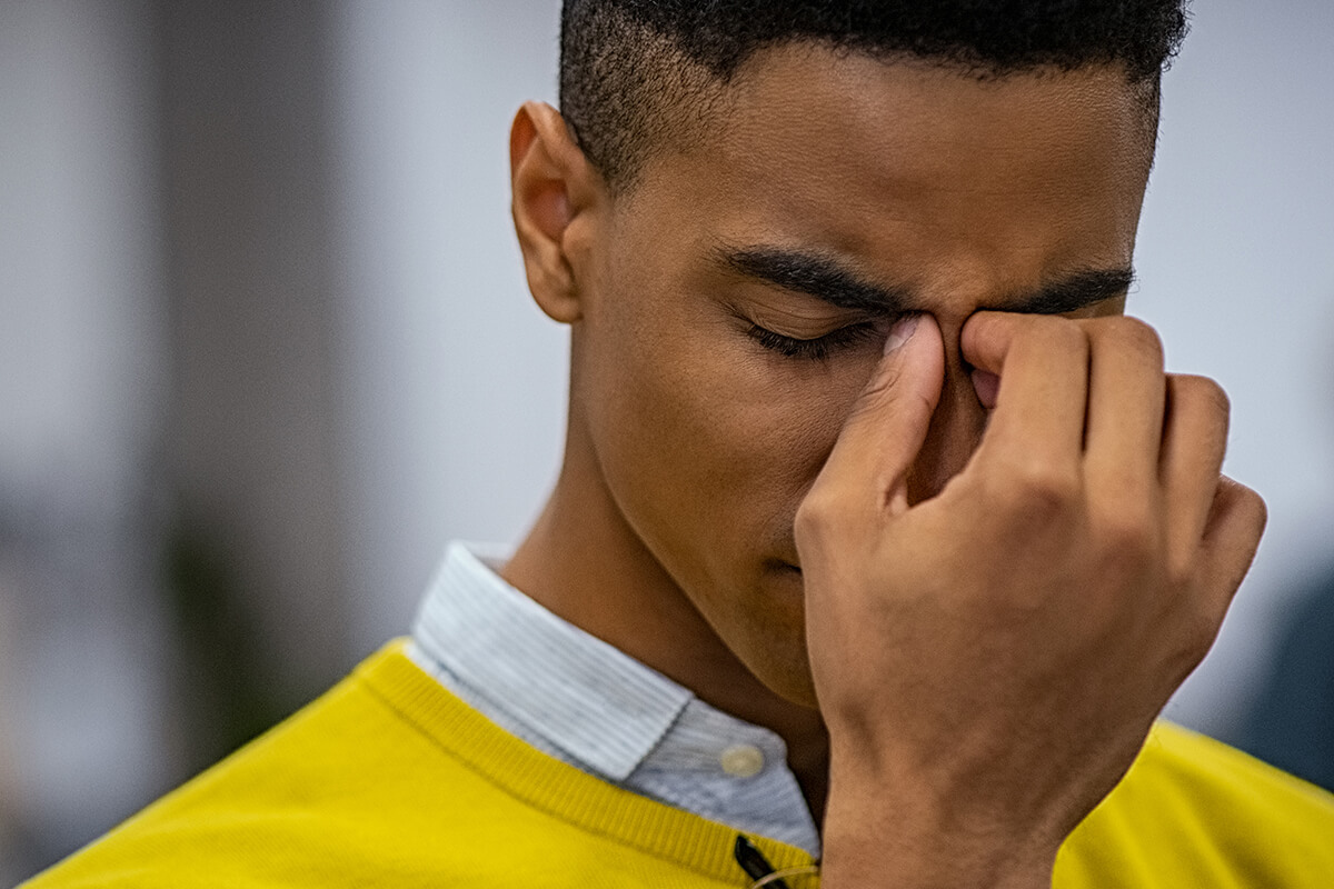 Man pinching between eyes in pain