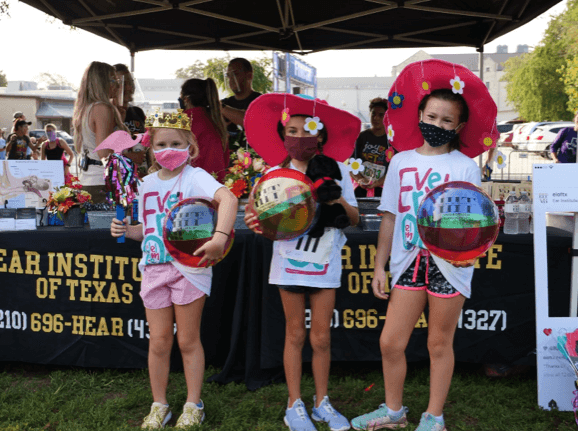 Three kids holding beach balls